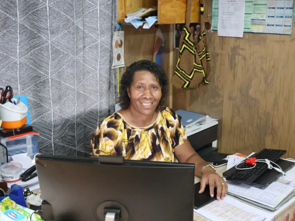 Jean Jano at desk smiling at camera